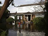 Jedna z postiených záplavami stojící na krabici ped svým domem