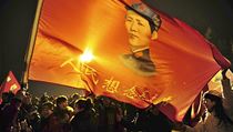 an s rudou vlajkou, na n je vyobrazen mlad Mao Ce-tung.