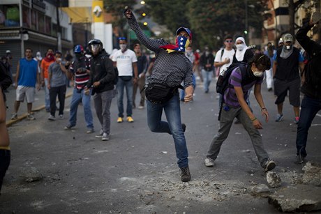 Demonstranti házejí kameny na Národní Bolívarovskou policii bhem protestu v Caracasu.