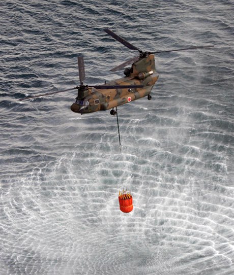 Vrtulník CH-47 Chinook nabírá moskou vodu, aby ze vzduchu pokropil bazén s vyhoelým palivem nad reaktorem 3 jaderné elektrárny Fukuima 1.