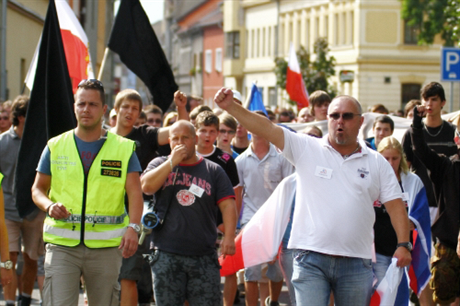 Demonstrace proti systému vyplácení sociálních dávek, proti duchcovské kriminalit v sobotu 24. srpna v Duchcov. Jindich Svoboda je uprosted v tmavém triku s megafonem pes rameno.