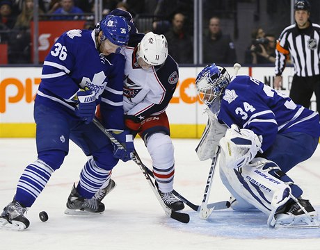 Obránce Toronto Maple Leafs bojuje o puk s hráem Columbusu