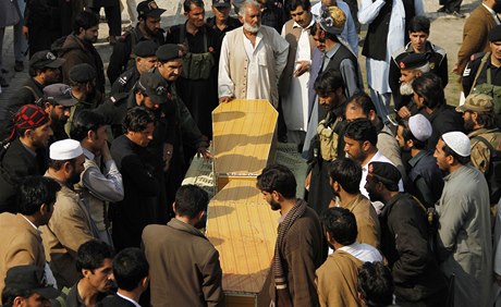 Píbuzní a ochranka odnáí rakve s mrtvými po pumovém útoku v pákistánsko-afghánském pohranií.