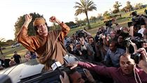 Kaddáfí zdraví příznivce ve svém tripoliském komplexu Báb al-Azízíja po nedělní schůzce s delegací Africké unie. Kaddáfí zdraví příznivce ve svém tripoliském komplexu Báb al-Azízíja po nedělní schůzce s delegací Africké unie.