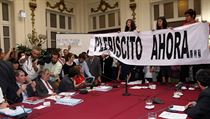 Ve čtvrtek 20. října proniklo v hlavním městě Chile Santiagu několik desítek demonstrujících studentů na zasedání senátní rozpočtové komise. Na stole, u nějž senátoři jednali, rozvinuli několikametrové transparenty, například s výzvou Plebiscito Ahora (P Ve čtvrtek 20. října proniklo v hlavním městě Chile Santiagu několik desítek demonstrujících studentů na zasedání senátní rozpočtové komise. Na stole, u nějž senátoři jednali, rozvinuli několikametrové transparenty, například s výzvou Plebiscito Ahora (P