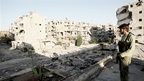 Bojovník opoziční Svobodné syrské armády pozoruje 12. srpna poškozené budovy a trosky na ulici předměstí severosyrského města Aleppo. Bojovník opoziční Svobodné syrské armády pozoruje 12. srpna poškozené budovy a trosky na ulici předměstí severosyrského města Aleppo.