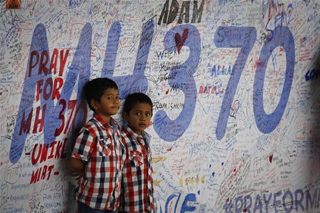 Dti stojí ped vzpomínkovou zdí ztraceného letounu Boeing777 na letiti v Kuala Lumpuru.
