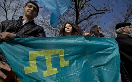 Mladí Krymtí Tati drí tatarskou vlajku bhem demonstrace proti pipojení Krymu k Rusku.