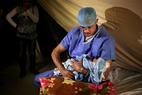 Novorozené miminko v nárui syrského lékae. Zdravotnická pée je na mnoha místech Sýrie v troskách, pes 40 procent nemocnic nefunguje.