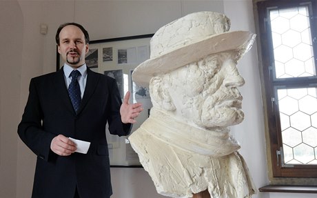 Kurátor výstavy Tomá Pavlíek u Hrabalovy busty od sochae Stanislava Hanzíka.