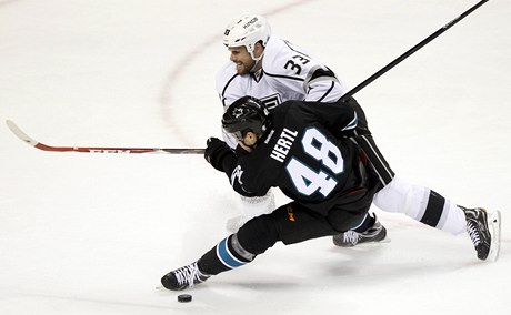 Obránce Los Angeles Willie Mitchell brání ve stelb útoníkovi San Jose Tomái Hertlovi