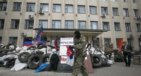 Proruský ozbrojenec ped zabarikádovanou budovou místní vlády v Kramatorsku