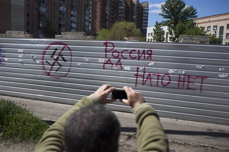 "Rusko ano, NATO ne." Mu si fotí graffiti na zdi ve Slavjansku.