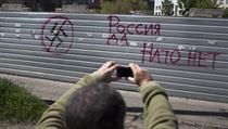 "Rusko ano, NATO ne." Muž si fotí graffiti na zdi ve Slavjansku. "Rusko ano, NATO ne." Muž si fotí graffiti na zdi ve Slavjansku.