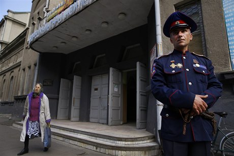 Kozák hlídá budovu, ve které probíhá referendum.