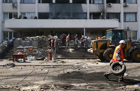 Zamstnanci Achmetovova Metinvestu uklízejí prostor ped mariupolskou radnicí.