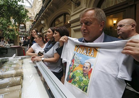 Mu si v moskevském nákupním stedisku GUM zkouí triko oslavující Putinv...