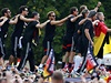 Fotbaloví ampioni slaví na projídjícím aut v ulicích Berlína.