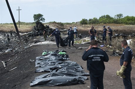 Zatímco ukrajintí záchranái odnáí tla v plastových pytlích, prorutí...