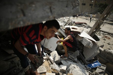 Palestinci prohledávají sutiny domu zasaeného izraelskými raketami.