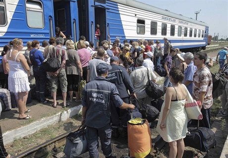 Uprchlíci z Luhanské oblasti nastupují do bezplatného vlaku smujícího do...