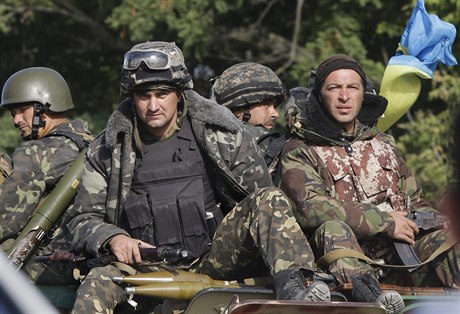 Ukrajintí vojáci, pipravující se na misi, projídí na transportéru východem...