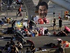 Demonstranti odpovaj v ulicch Hongkongu. Na sloupu vis vylepen portrt...