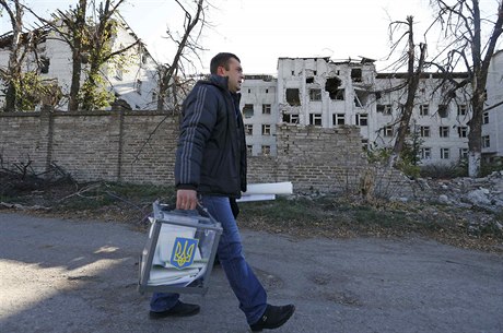 Ukrajinský volební komisa s urnou kráí kolem dom, zniených bhem obanské...