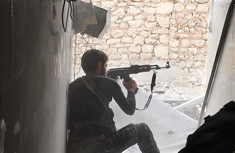 Bojovník IS v Kobani pálí ze samopalu.
