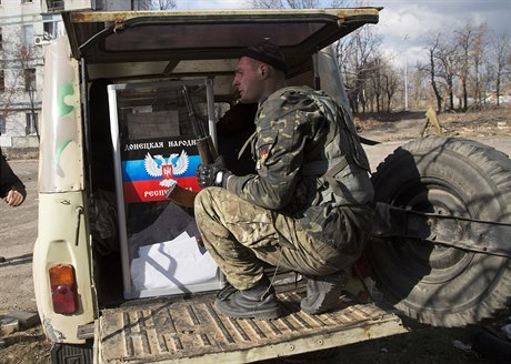 Ozbrojený separatista hlídá volební urnu.
