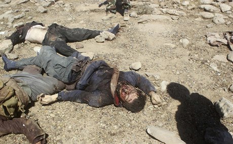 Stín iráckého vojáka nad mrtvými tly bojovník Islámského státu.