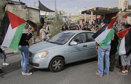 Palestintí demonstranti blokují prjezd izraelského osadníka. Auta se v...