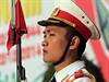 Voják stojí ped obím plakátem oslavujícím 70. narozeniny Vietnamské lidové...