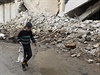 Chlapec s krlkem v ruce prochz rozbombardovanou ulic Aleppa.