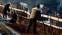 Dělníci pokládají při kraji mostu síť z železných drátů, které se po betonáži promění v masivní svodidla. V pozadí je portál tunelu. | na serveru Lidovky.cz | aktuální zprávy