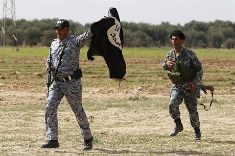 Vítzní vojáci s ukoistnou vlajkou Islámského státu (ilustraní snímek).