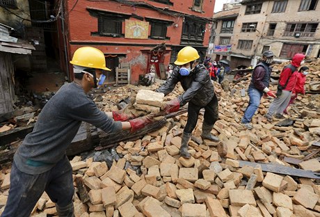 Dobrovolníci odklízejí trosky zícených dom (Káthmándú).