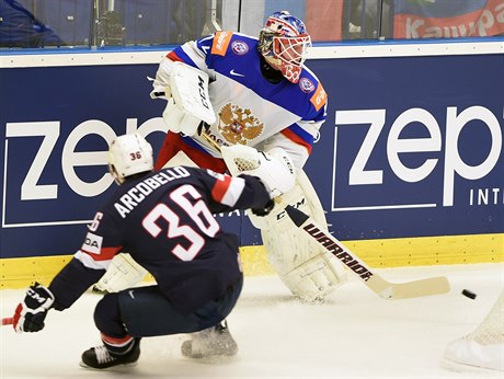 Ruský branká Sergej Bobrovskij odehrává puk ped americkým útoníkem Markem...