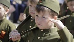 Salutující chlapec v historické vojenské uniform.