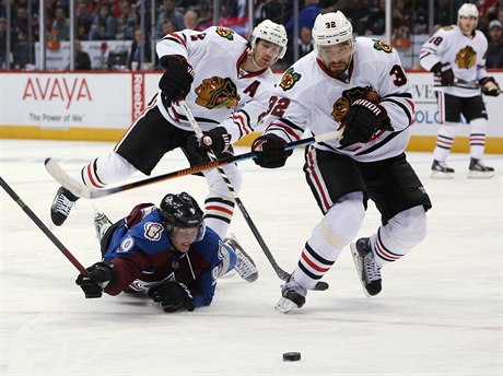 Obránce Chicago Blackhawks Michal Rozsíval vyráí k puku, zatímco center...