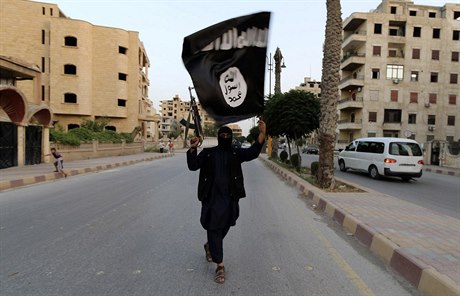 Ozbrojený radikál s ernou vlajkou Islámského státu (ilustraní snímek).