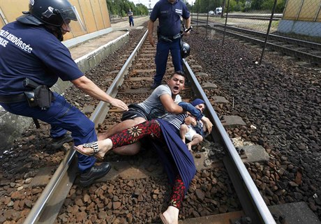 Uprchlíci si lehají na koleje u maarského msteka Bicske, kde policie...
