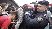 Ndra Nickelsdorf: Policista vytahuje z davu uprchlk malou holiku, aby...