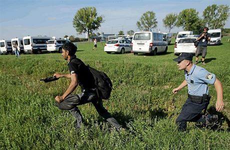 Chorvatský policista se snaí poblí Tovarniku dostihnout migranta, který do...
