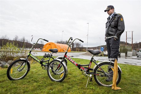 Norský policista pozoruje kola, které uprchlíci pouili k pekroení hraniního...