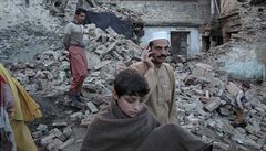 Lidé procházejí troskami zniených dom v Pákistánu po zemtesení.