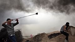 Náctiletí Palestinci hazí kameny na Izraelce