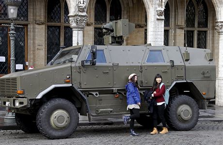 Pár turist se pece jen najde. Pózují u armádního vozidla.
