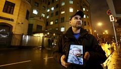 Ruský aktivista, který drí v ruce tablet s fotografií mrtvého pilota ruské...