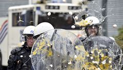 Lidé házejí vajíka na bruselskou policii bhem demonstrace.